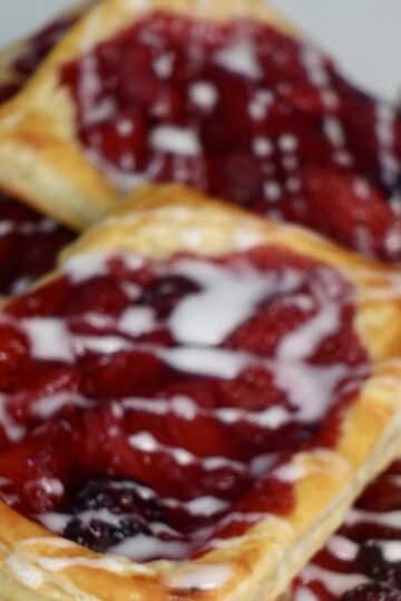 Berry puff pastry filled with homemade strawberry and blackberry compote and drizzled with vanilla glaze.