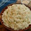 Bowl of fluffy coconut jasmine rice made with full-fat coconut milk and topped with toasted coconut flakes.