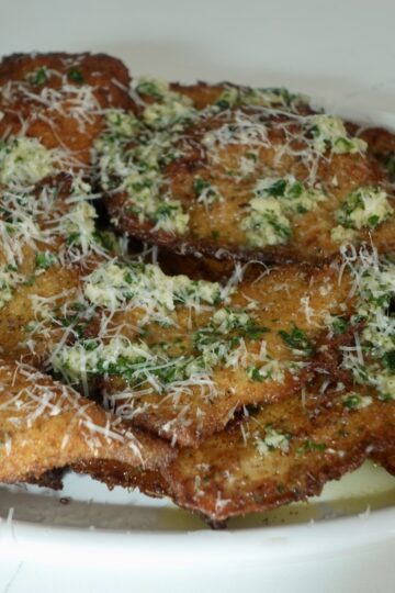 Garlic Parmesan chicken cutlets topped with Parmesan and fresh parsley.