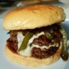 Philly cheesesteak burger with double beef patties, creamy cheese sauce, peppers and onions.