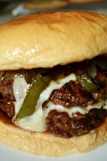 Philly cheesesteak burger with double beef patties, creamy cheese sauce, peppers and onions.