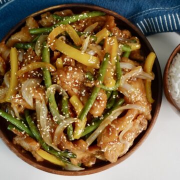 honey sesame chicken breast with green beans and yellow bell peppers served over jasmine rice.
