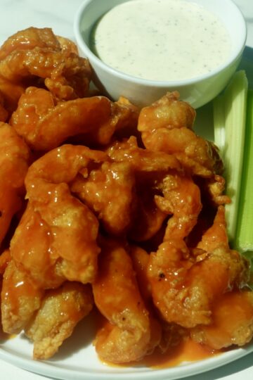 Crispy butterflied fried shrimp coated in spicy buffalo sauce served with creamy ranch dressing and celery sticks.