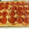 Homemade sheet pan pepperoni pizza with mozzarella, Parmesan, and tomato sauce on a golden chewy crust.