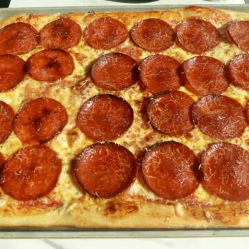Homemade sheet pan pepperoni pizza with mozzarella, Parmesan, and tomato sauce on a golden chewy crust.