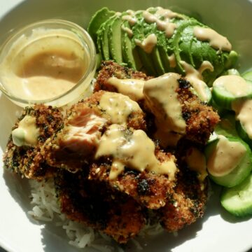 Seaweed-crusted salmon bites with a golden, crunchy panko and roasted seaweed coating, served over white rice with cucumber, edamame and bang bang dipping sauce.