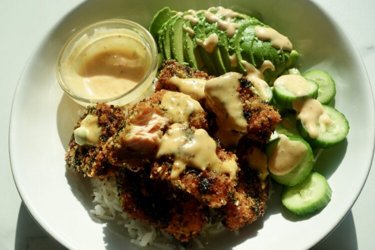 Seaweed-crusted salmon bites with a golden, crunchy panko and roasted seaweed coating, served over white rice with cucumber, edamame and bang bang dipping sauce.